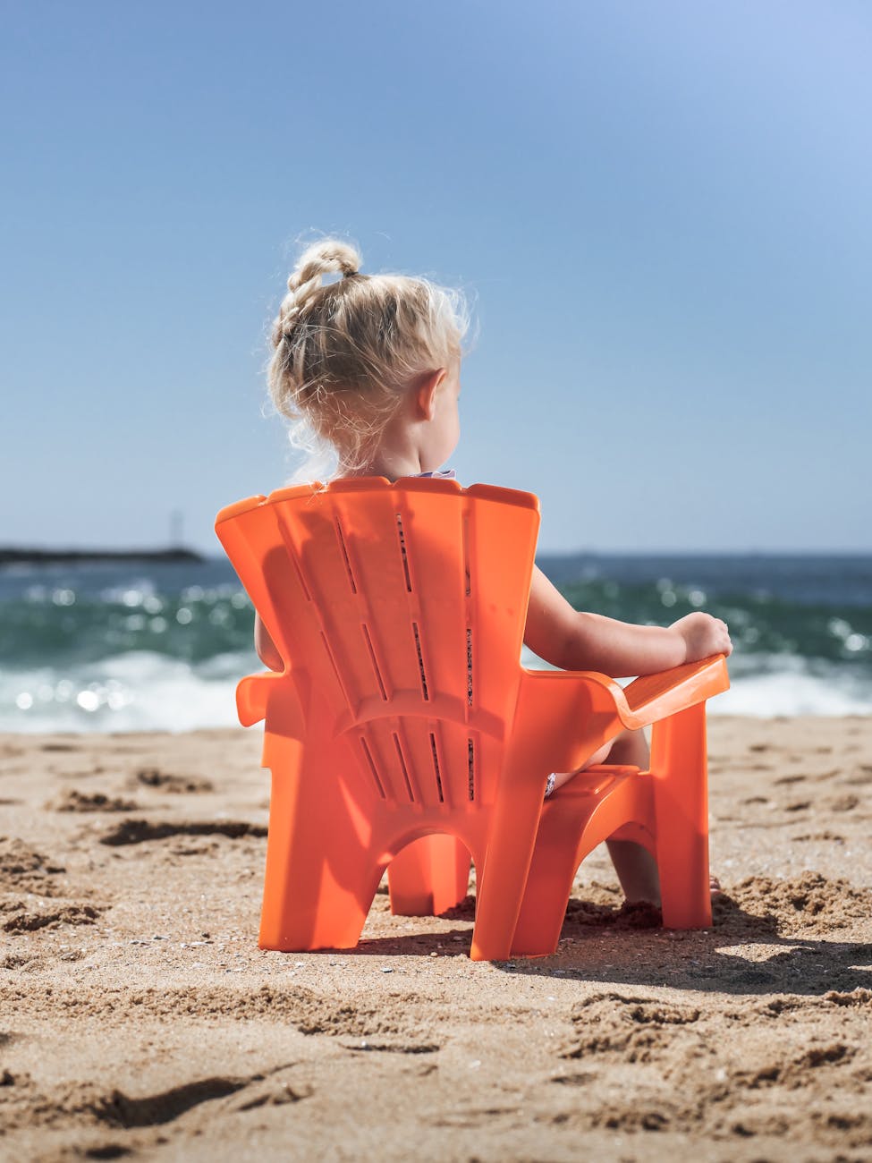 girl sitting on a chair at a beach